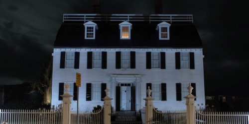 The forbidding exterior of the Ropes Mansion, Salem, MA at night, with the attic windows alight, what happens there? Join our tour to find out.